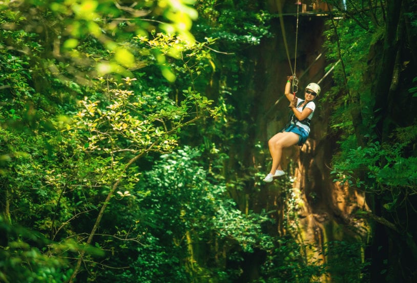 Woman enjoying the thrill of zip lining through the jungle on women's tour to Costa Rica.