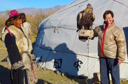 Outside a Kazakh hunters ger AdventureWomen learn how to hold eagles.