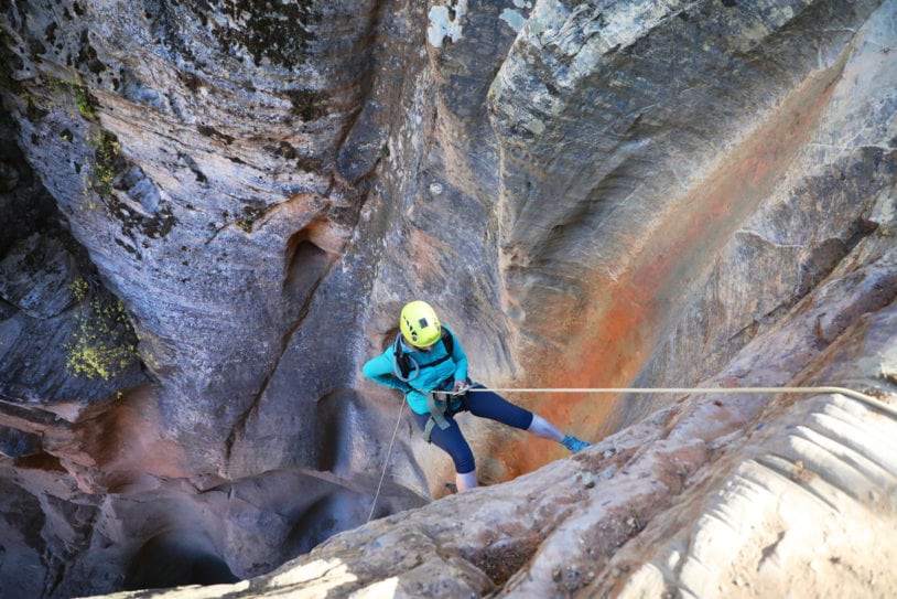 Female descending with rope on guided canyoneering women only adventure trip in Utah