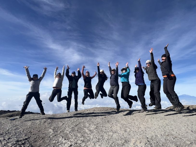 Group of AdventureWomen jumping synchronized and triumphantly on Mt Kilimanjaro