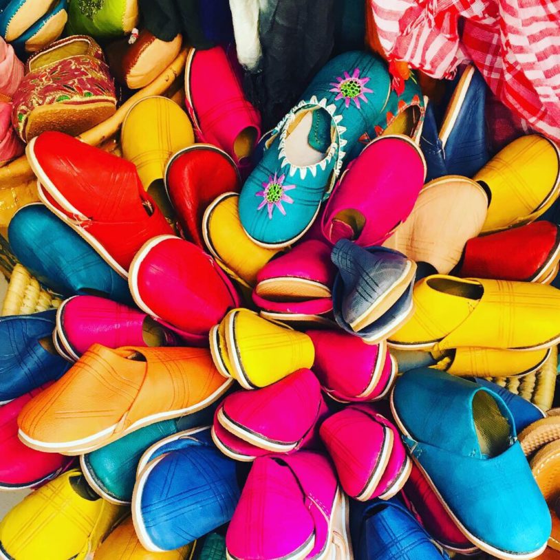 pile of brightly colored locally made shoes at market in morocco