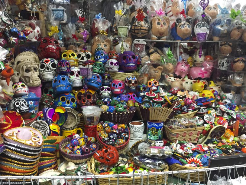 Diverse colorful Mexican traditional handcraft for day of the dead and other celebrations, in a market stall