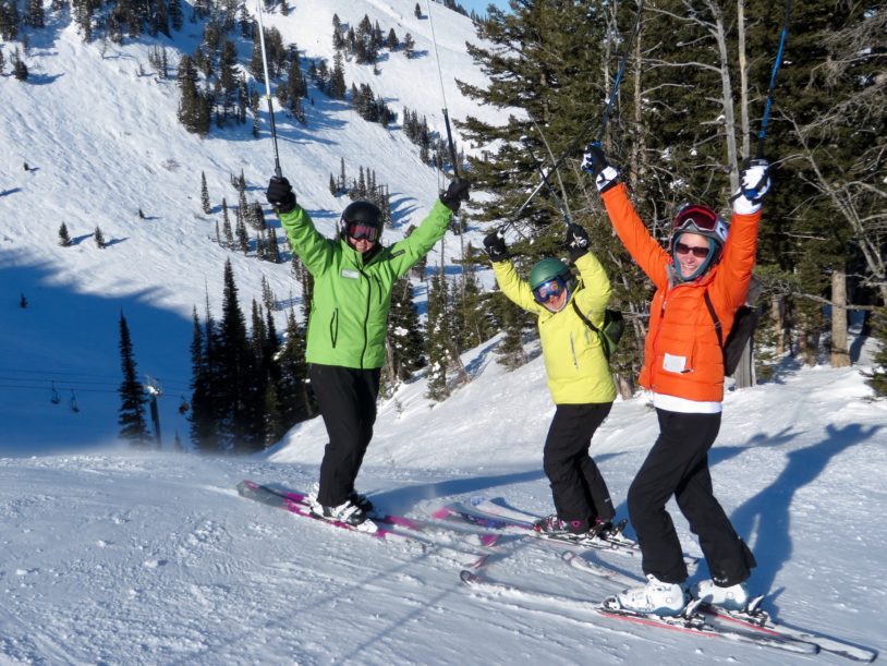 Three women in ski lessons posing with joy