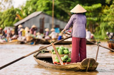 Vietnamese women steering a boat to market in Mekong Delta