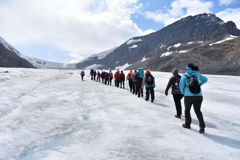 A line of women hiking across Columbia ice field