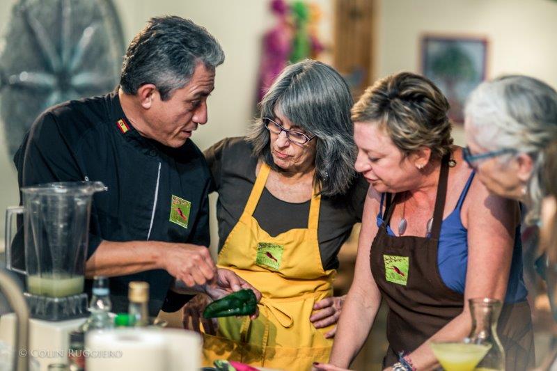 Women gathered around a chef for a Mexcian cooking class