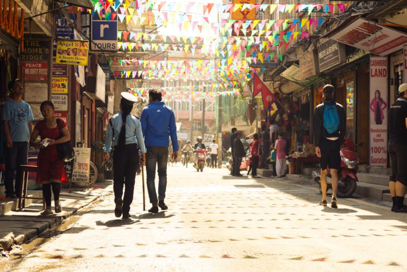 Morning View of Kathmandu City Street holiday decorated and some local and foreign People including Police Woman walking at warm Morning Sunlight. Kathmandu,