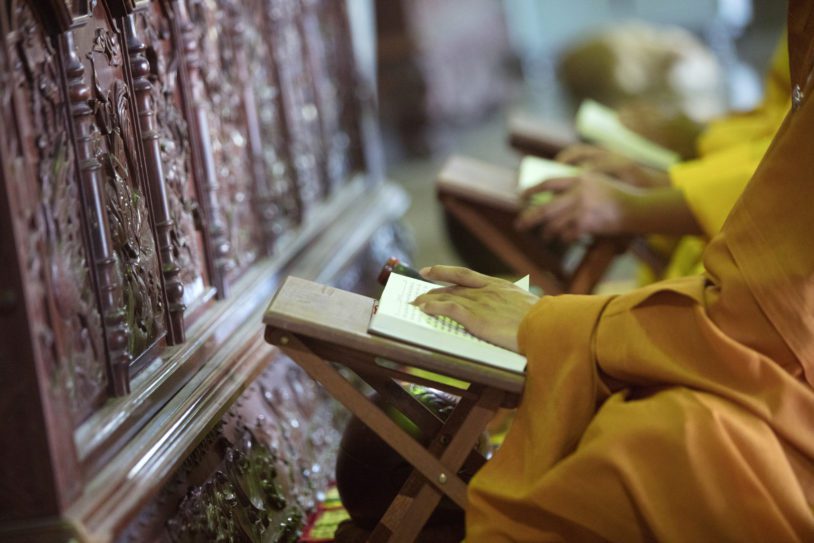 Hands of Buddist Monks placed on books
