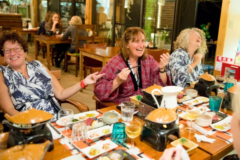 Travelers laughing over a meal in Kumano Kodo